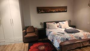 a bedroom with a bed and a chair at Tucked away with a pool view in White River