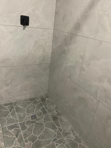 a bathroom with a shower with a tiled floor at Tucked away with a pool view in White River