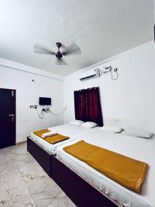 a bedroom with a bed with a ceiling fan at Auro Breeze Villa Inn in Puducherry