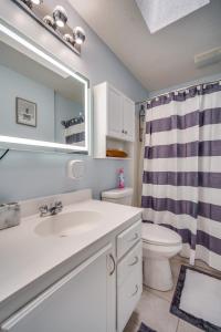 a bathroom with a sink and a toilet and a mirror at King Bed with Pool Table in Chicopee