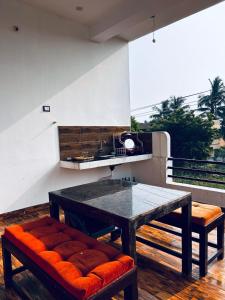 a table and benches on a balcony with a table and chairs at Auro Breeze Villa Inn in Puducherry +7 photos