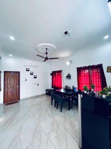 a living room with a table and red curtains at Auro Breeze Villa Inn in Puducherry