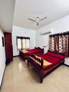 a bedroom with two beds and a ceiling fan at Auro Breeze Villa Inn in Puducherry