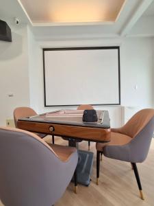 a conference room with a table and chairs and a projection screen at 宜蘭花境民宿 in Wujie