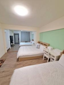 a hotel room with two beds and a table at 宜蘭花境民宿 in Wujie