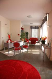 - un salon avec des chaises rouges et un tapis rouge dans l'établissement Domaine de Chantemerle, à Moutiers-sous-Chantemerle