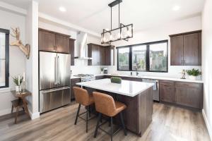 una cucina con armadi in legno e un'isola cucina con sgabelli. di Lofty Landing a Hideaway Park