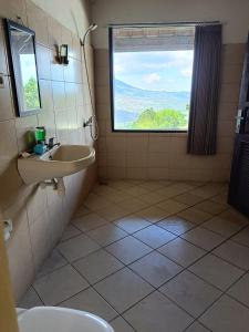 een badkamer met een wastafel en een raam bij Mountview Bali in Kubupenlokan