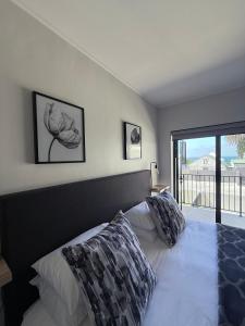 サイモンズタウンにあるMountain Bay Apartment with Sea and Mountain Viewsのベッドルーム1室(枕付きのベッド1台、窓付)
