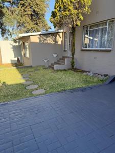a home with a brick driveway in front of a house at Goshen in Johannesburg