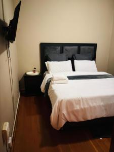 a bedroom with a large bed with white sheets and pillows at Goshen in Johannesburg