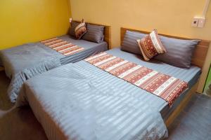 two beds sitting next to each other in a room at Anlani homestay in Ha Giang
