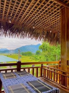 a porch with a table and a view of a field at An Huy Homestay Mai Châu in Mai Chau