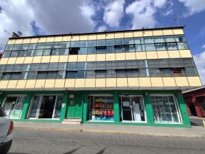 a building with a green and yellow facade at Departamento acogedor y céntrico in Oaxaca City