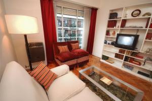 sala de estar con sofá y TV en Mena House en Recoleta 3 Bed 2 Bath - Piso Alto en Buenos Aires
