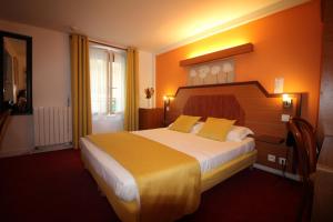 um quarto de hotel com uma cama grande com almofadas amarelas em Le Nouvel Hôtel du Théâtre em Paris