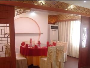 een eetkamer met een rode tafel en stoelen bij Jintone Hotel Beiliu Yongan Branch in Beiliu
