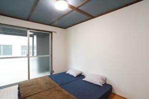 a bedroom with a bed and a large window at ひだまりの宿 まゆしょう in Omachi