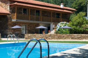 a house with a swimming pool in front of a house at Quinta Vilar e Almarde in Castelo de Paiva