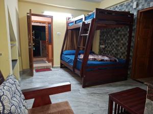 科代卡纳尔Jmholidayinn的带两张双层床的客房和门廊