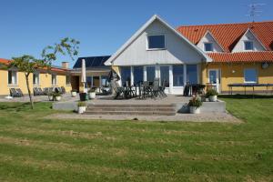 a house with a patio with tables and chairs at Hotel Højgaarden in Slettestrand