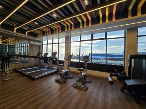 a gym with cardio equipment in a building with windows at Hotel Maximillian in Tanjung Balai Karimun