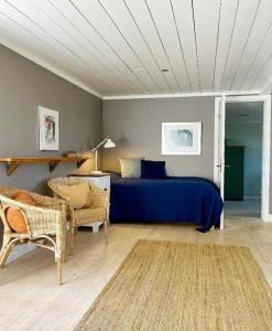 Un dormitorio con una cama azul y una silla. en Historic Halland Farm Near The Sea In Bua, en Väröbacka 9 fotos más