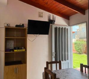 comedor con mesa y TV en la pared en Departamentos Turísticos, en Cosquín