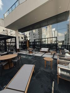 a rooftop patio with tables and benches on a building at Apartamento 3 dormitórios quadra da praia in Balneário Camboriú