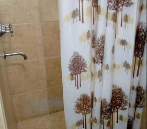 cortina de ducha con árboles en el baño en Departamentos Turísticos, en Cosquín