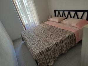 a bedroom with a bed with a blanket and a window at Casa vacanze nel Parco della Majella in Montenerodomo