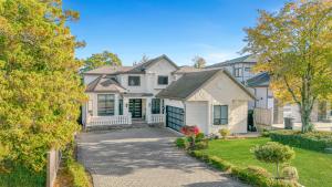 a large white house with a driveway at 8BR New Spacious Home White Rock HVAC Free Parking in Surrey