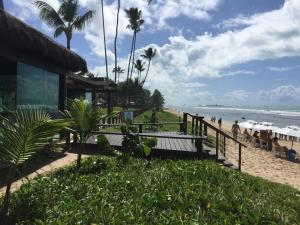 a beach with a building and people on the beach at Marulhos Resort Muro Alto Studio in Porto De Galinhas