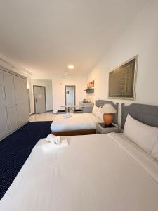 a hotel room with two beds and a bathroom at Rainbow Paradise BeachFront Penang in Tanjung Bungah