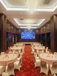 a banquet hall with white tables and white chairs at Hotel Maximillian in Tanjung Balai Karimun