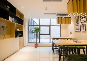 a dining room with yellow cabinets and a table and chairs at City Comfort Inn Suzhou Zhangjiagang Jingang Changjiang Xi Road in Xiwujieqiao