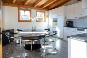 a kitchen with a table and chairs in a room at Cozy alpine loft with fireplace in Lenz