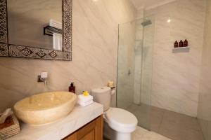 ein Badezimmer mit Waschbecken, Toilette und Dusche in der Unterkunft Hideaway Boutique - Uluwatu by Kanaan Hospitality in Uluwatu + 18 Fotos