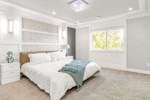 a white bedroom with a large bed and a window at 8BR New Spacious Home White Rock HVAC Free Parking in Surrey