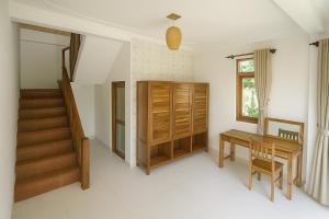 a room with a desk and a table and a window at Coconut Garden Mui Ne in Mui Ne