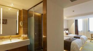 een badkamer met een bed, een wastafel en een spiegel bij James Joyce Coffetel Taizhou Jiangyan Bus Terminal in Magou +244 foto's