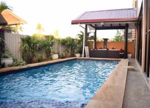 a swimming pool with a gazebo next to a house at Al - Minhaj Service Apartments in Nadi