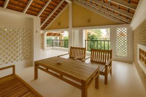 a dining room with a wooden table and two chairs at Coconut Garden Mui Ne in Mui Ne +30 photos