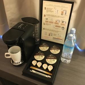een koffiezetapparaat, een kopje en een fles water bij Hotel Sunroute Fukuchiyama in Fukuchiyama