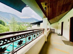 un edificio con balcón con vistas a una piscina en Hotel Inn Way #Near Beas River, en Manali