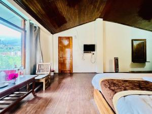 Un dormitorio con una cama y un escritorio y una ventana. en Hotel Inn Way #Near Beas River, en Manali