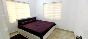 a bed in a room with two windows at Heaven Cloud Stay Hub Attappadi in Attappādi