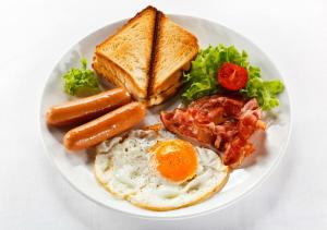 a plate of breakfast food with eggs sausage and toast at Stay199 in Haragama