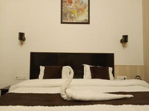a bedroom with two beds with a large headboard at Trans Varuna Inn in Varanasi