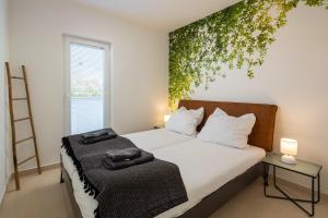 a bedroom with a bed with a plant on the wall at Villa 5 elements in Gostinjac +62 photos